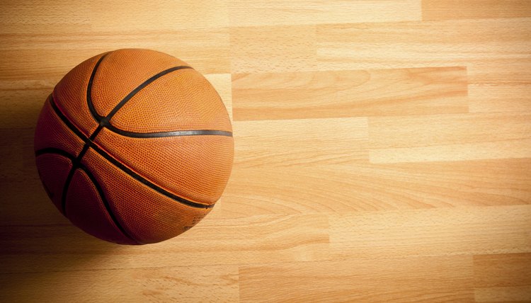 An official orange ball on a hardwood basketball court