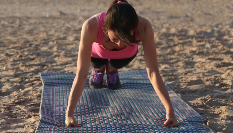 Young women doing pushups on the beach