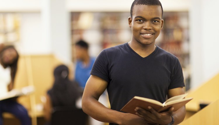 A student browses through a book at the library.