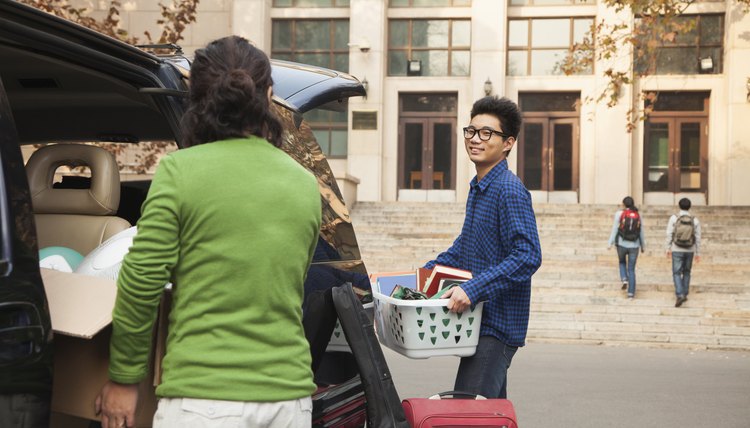 A young man is moving into his college dorm.