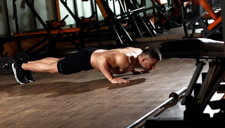 Muscular man doing a pushups at gym.