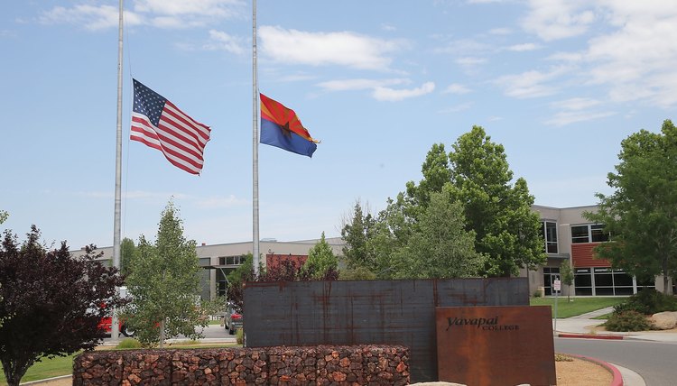 The American and State of Arizona flags fly at half mast to honor fallen firefighters killed in Yarnell Hills wildfire in July 2013