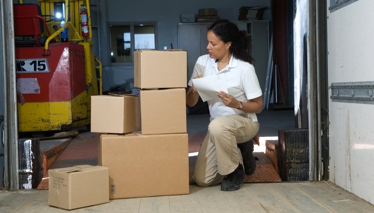 Woman taking inventory of boxes on loading dock
