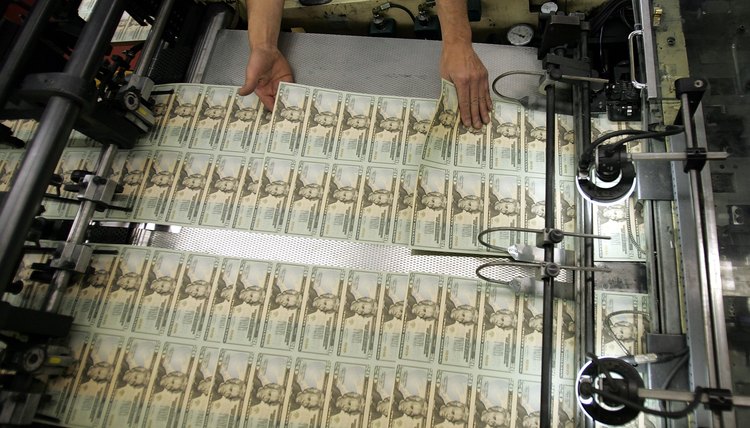 Worker looks for defective bills in newly printed U.S. twenty dollar bill sheets