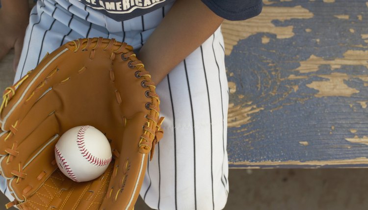 High angle view of a young boy wearing a baseball mitt holding a ball