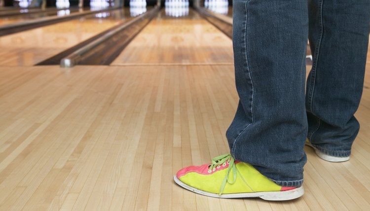 Low section view of a young person standing in a bowling alley