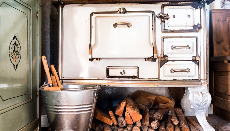 An antique cooking stove and wood pile in an old farmhouse.