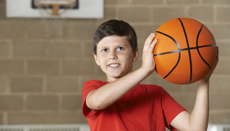 Boy Shooting During Basketball Match In School Gym