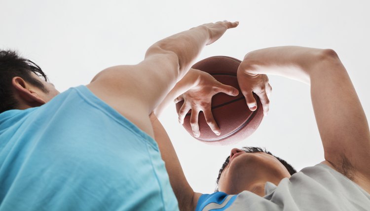 Two people playing basketball, blocking 