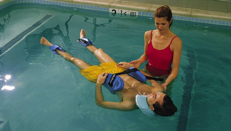 Physical therapist with patient in pool
