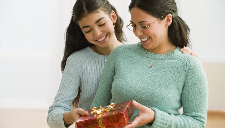 Daughter giving her mother a wrapped birthday present.