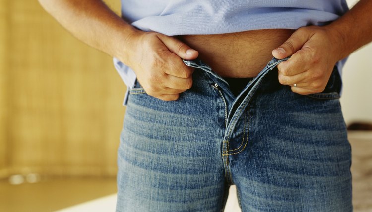 mid section view of a man buttoning his jeans