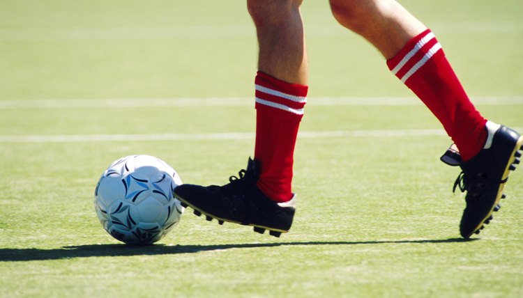 Feet of soccer player kicking ball