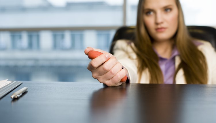 Businesswoman squeezing stress toy