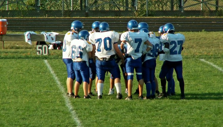 A group of football players practice on a field.