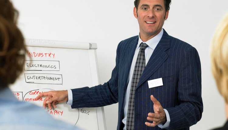 Businessman giving presentation, pointing to flipchart, smiling