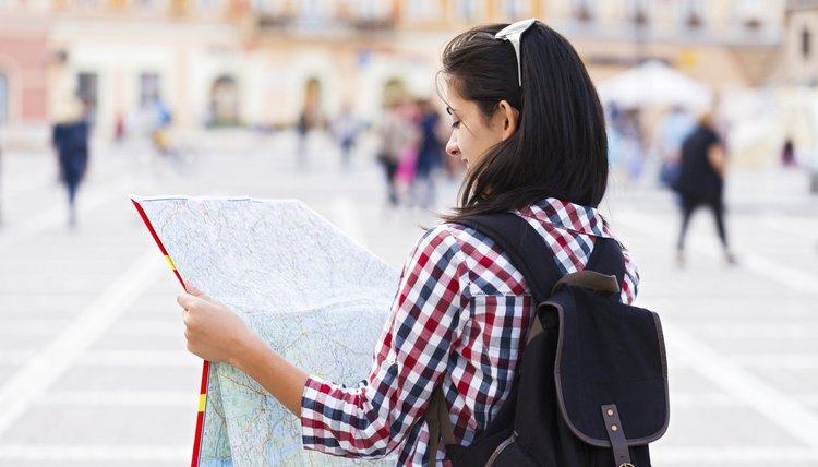 Student holding map up in foreign country