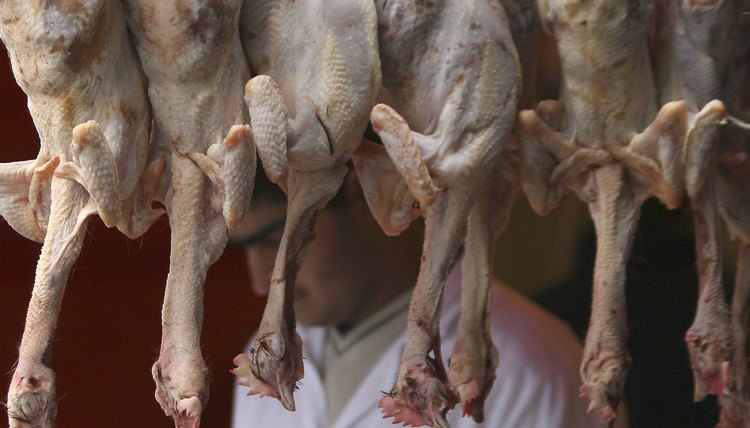 Chickens hang for sale in a halal butcher shop.