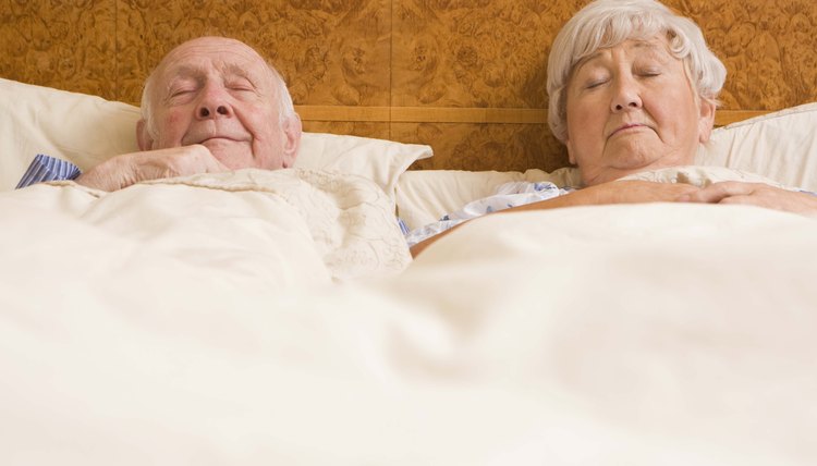 Elderly couple sleeping in bed