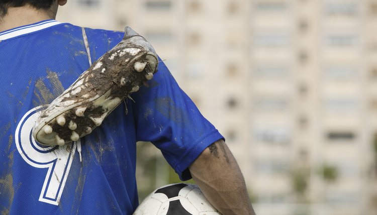 Soccer Player Carrying Muddy Shoes