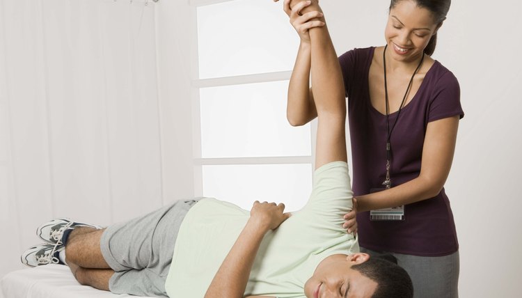 Physical therapist stretching arm of patient