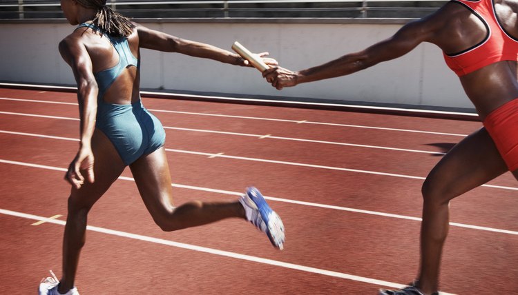 Women passing baton to each other during race