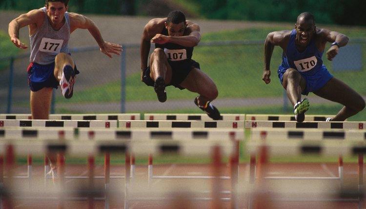 Runners jumping over hurdles