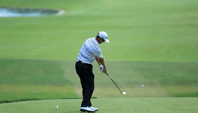 As PGA Tour player John Senden hits this draw, notice that he has set up on the left side of the tee box and his feet are aimed to the right.