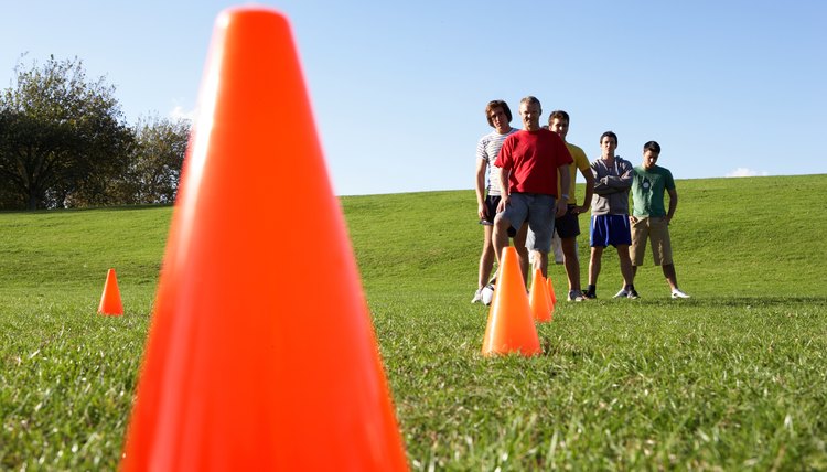 Group of men in field with cones