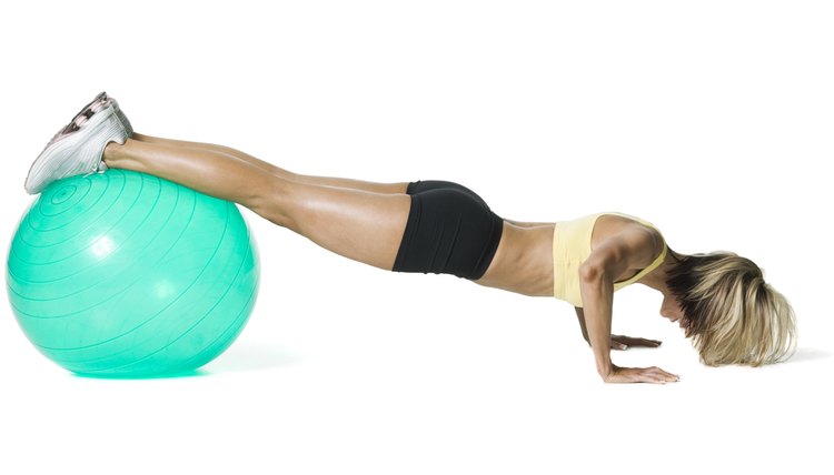 full body shot of a young woman in a yellow and black exercise outfit as she does push ups