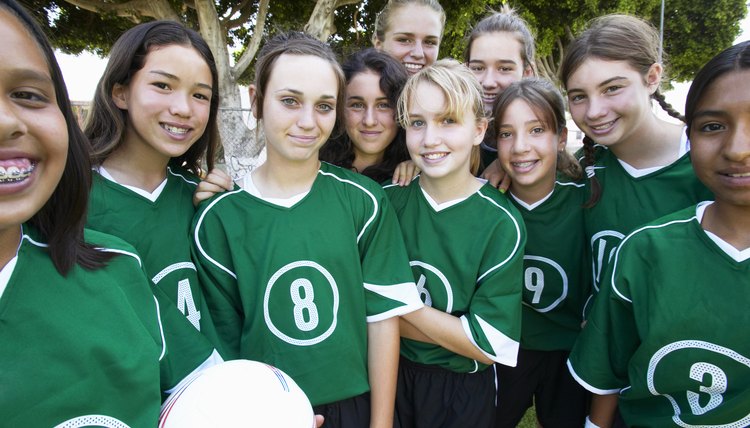 Girls (12-15) football team, smiling, portrait