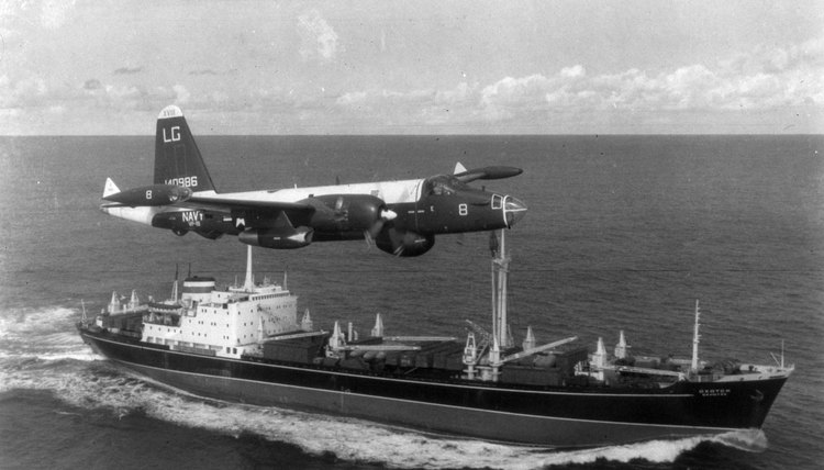 A P2V Neptune U.S. patrol plane flies over a Soviet freighter during the Cuban missile crisis in this 1962 photograph.