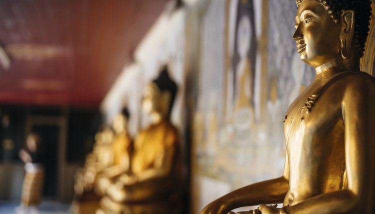 A row of golden Buddha statues inside of a temple.