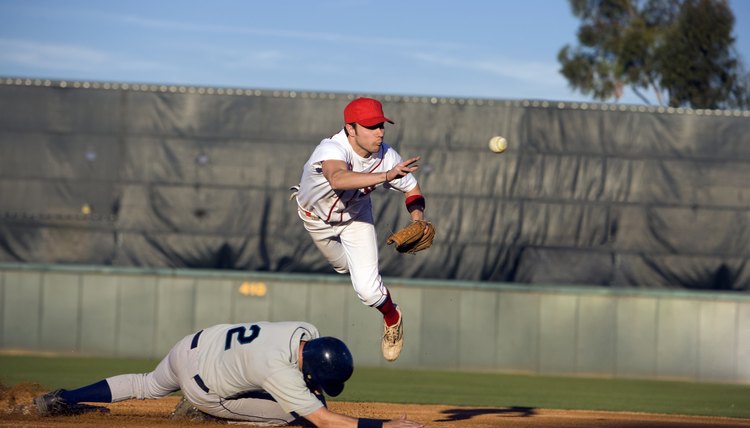 USA, California, San Bernardino, baseball runner sliding for base and baseman leaping for catch