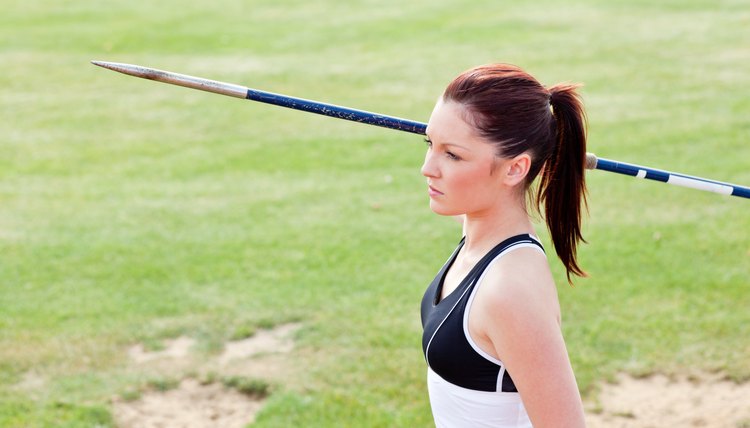 Concentrated female athlete ready to throw javelin