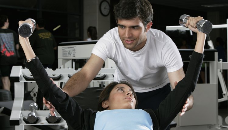 Young man teaching a young woman in a gym