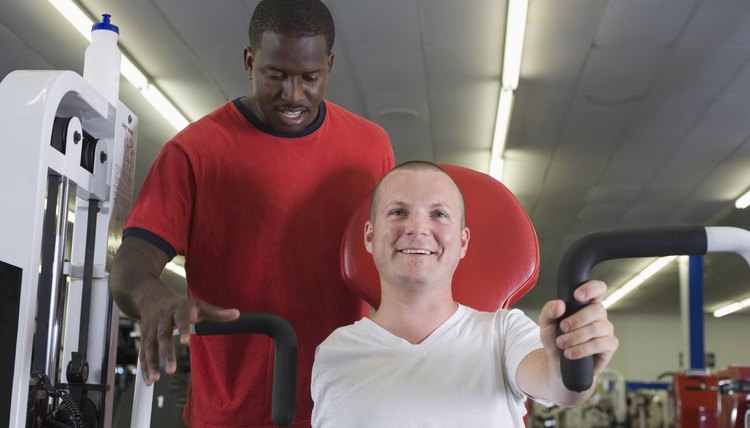 One-armed man in gym with trainer