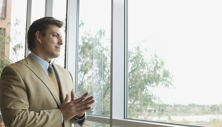 A businessman is looking out the window.