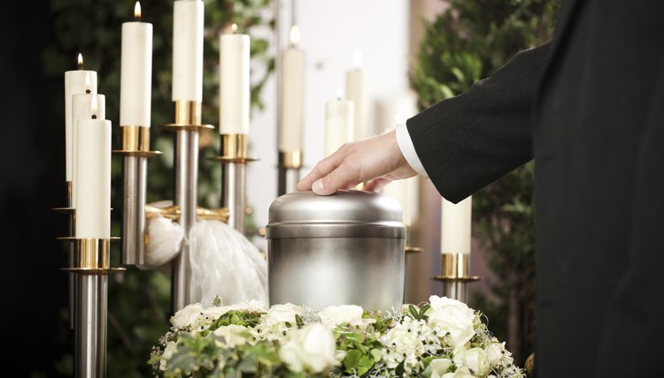 Man resting hand on cremated ashes at funeral