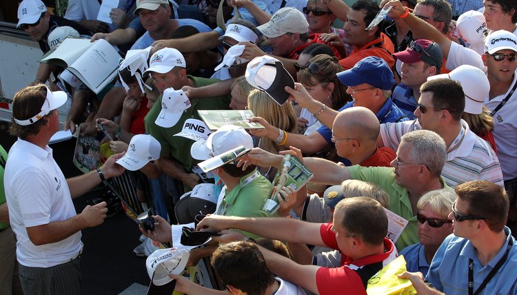 Phil Mickelson, left, signs autographs after playing a round at the 2012 Arnold Palmer Invitational.