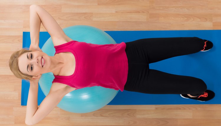 High Angle View Of Young Happy Woman Lying On Exercise Ball