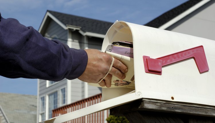 Postal worker delivering mail to a letterbox.