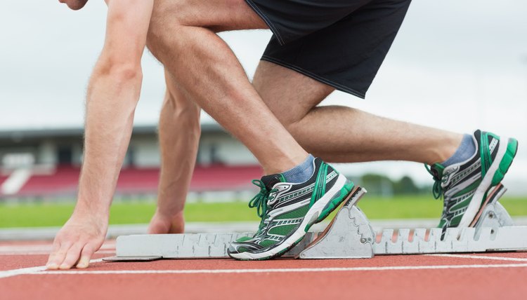 Side view of a man ready to race on running trac