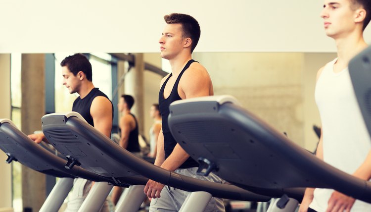 group of men exercising on treadmill in gym