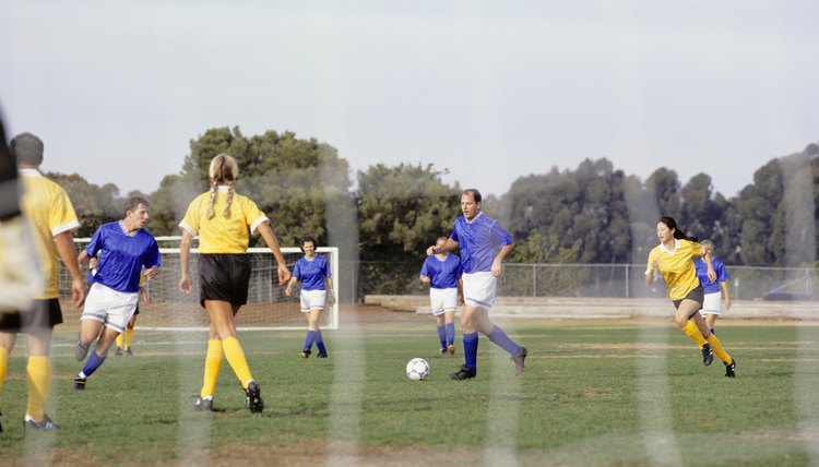 Mixed football team playing on grass pitch