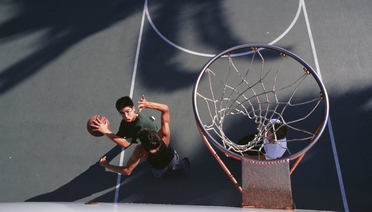 Three teenage boys (16-17) playing basketball, elevated view