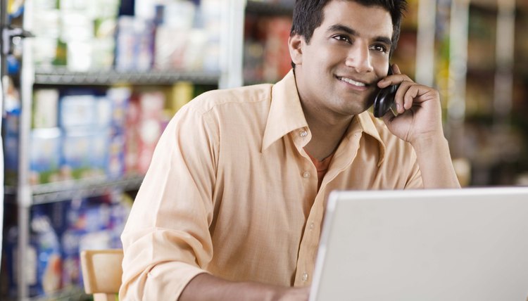 Man on cell phone with laptop