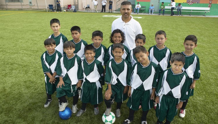 Portrait of boys (7-11) football team with coach