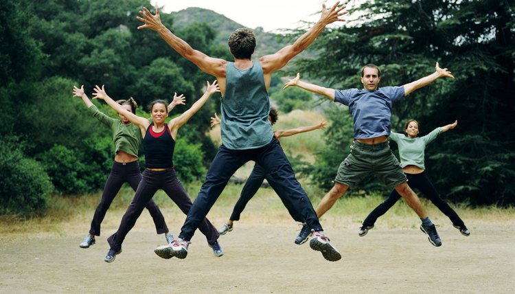 Man leading group of people in boot camp exercises, rear view