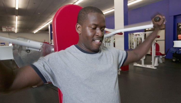 Man using shoulder machine in gym